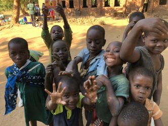 Group of smiling children reaching toward camera
