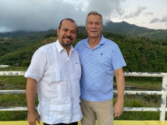 Two men smiling on mountain overlook